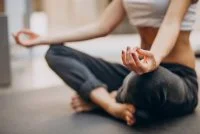 Young woman practicing yoga at home &copy; freepik