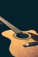 Musical background with acoustic guitar close up. &copy; freepik